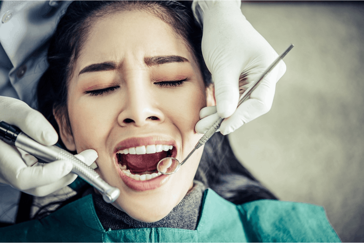 Woman in dental chair experiencing discomfort during emergency dental treatment in Gainesville.